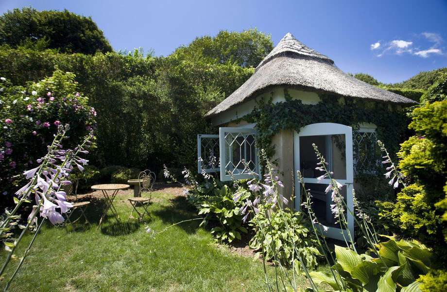 At Grey Gardens, hostas bloom along the facade of a garden folly.