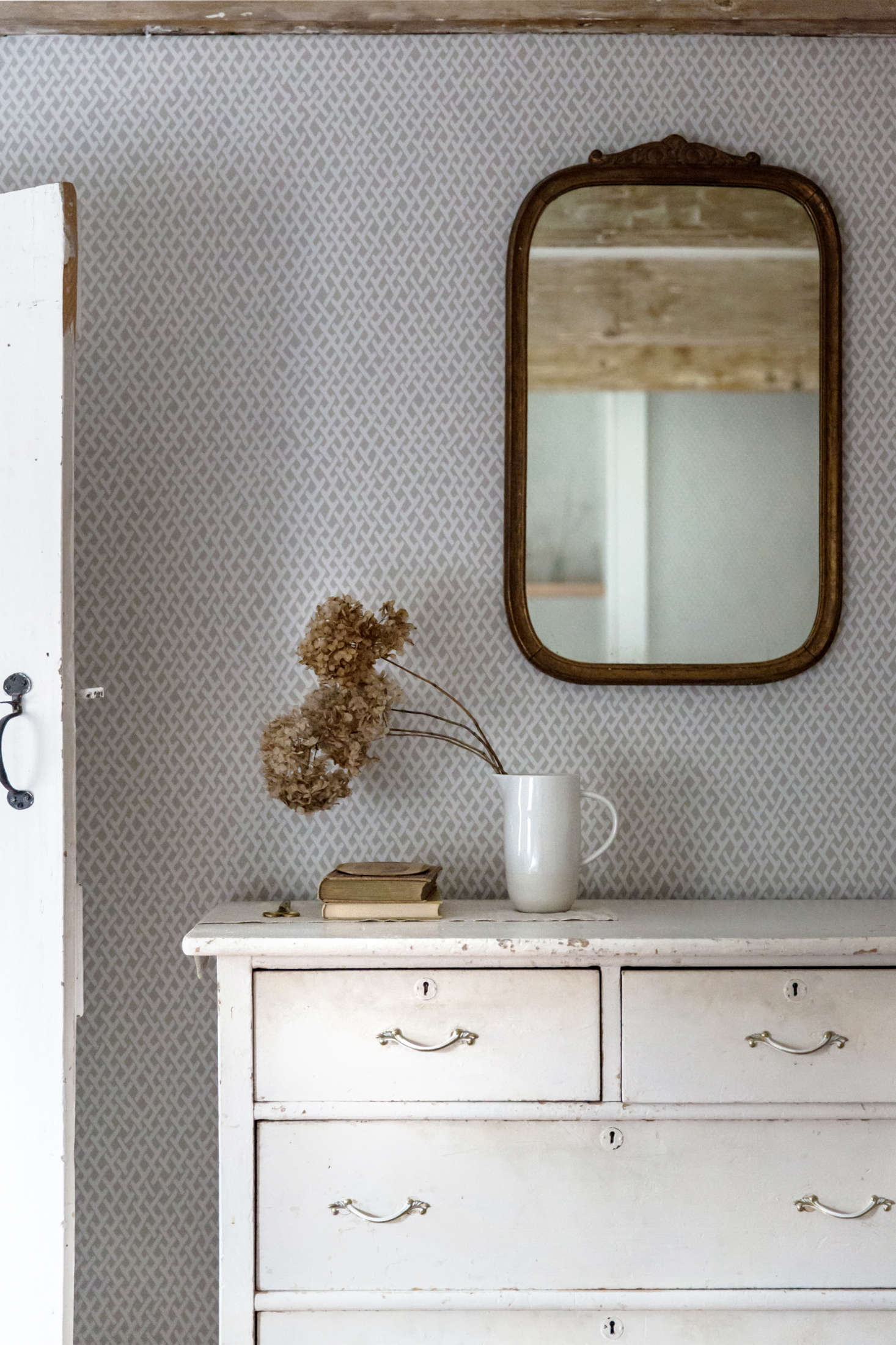 In a pitcher instead of a vase, dried hydrangeas are in motion, spilling out against a static backdrop of Farrow & Ball wallpaper. Photograph by Beth Kirby of Local Milk.