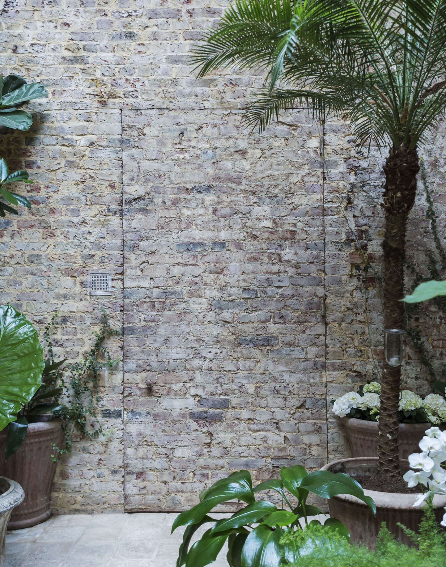 Layers of plaster were stripped from the walls, revealing bare brick Uniacke elected to leave raw. To camouflage a door that connects the conservatory to the original owner