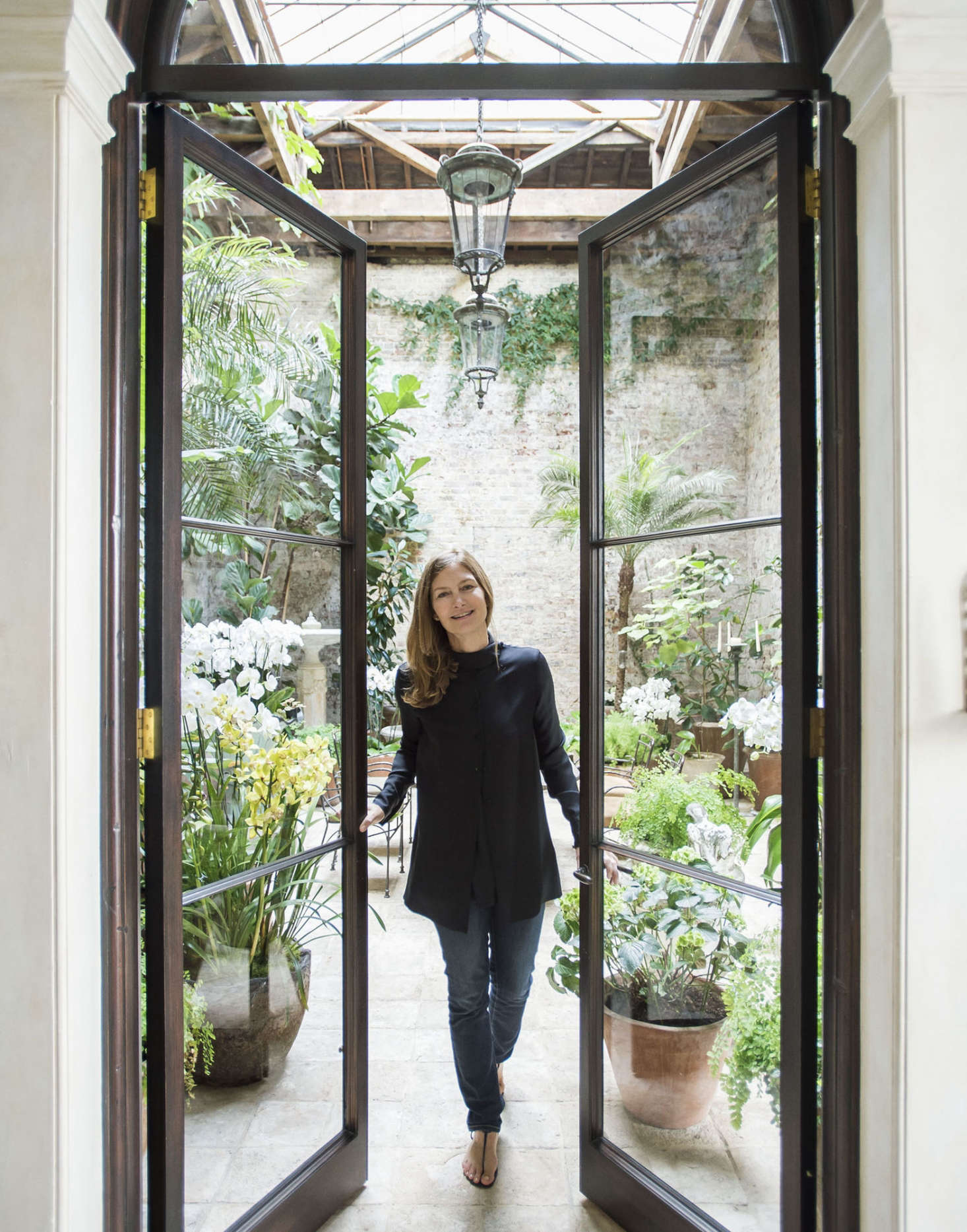 Designer Rose Uniacke’s glass-roofed conservatory is home to dozens of potted orchids.