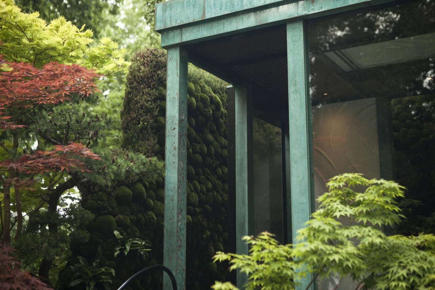 A vertical plane of moss (you could call it a wall) for viewing, within the wall-less building.