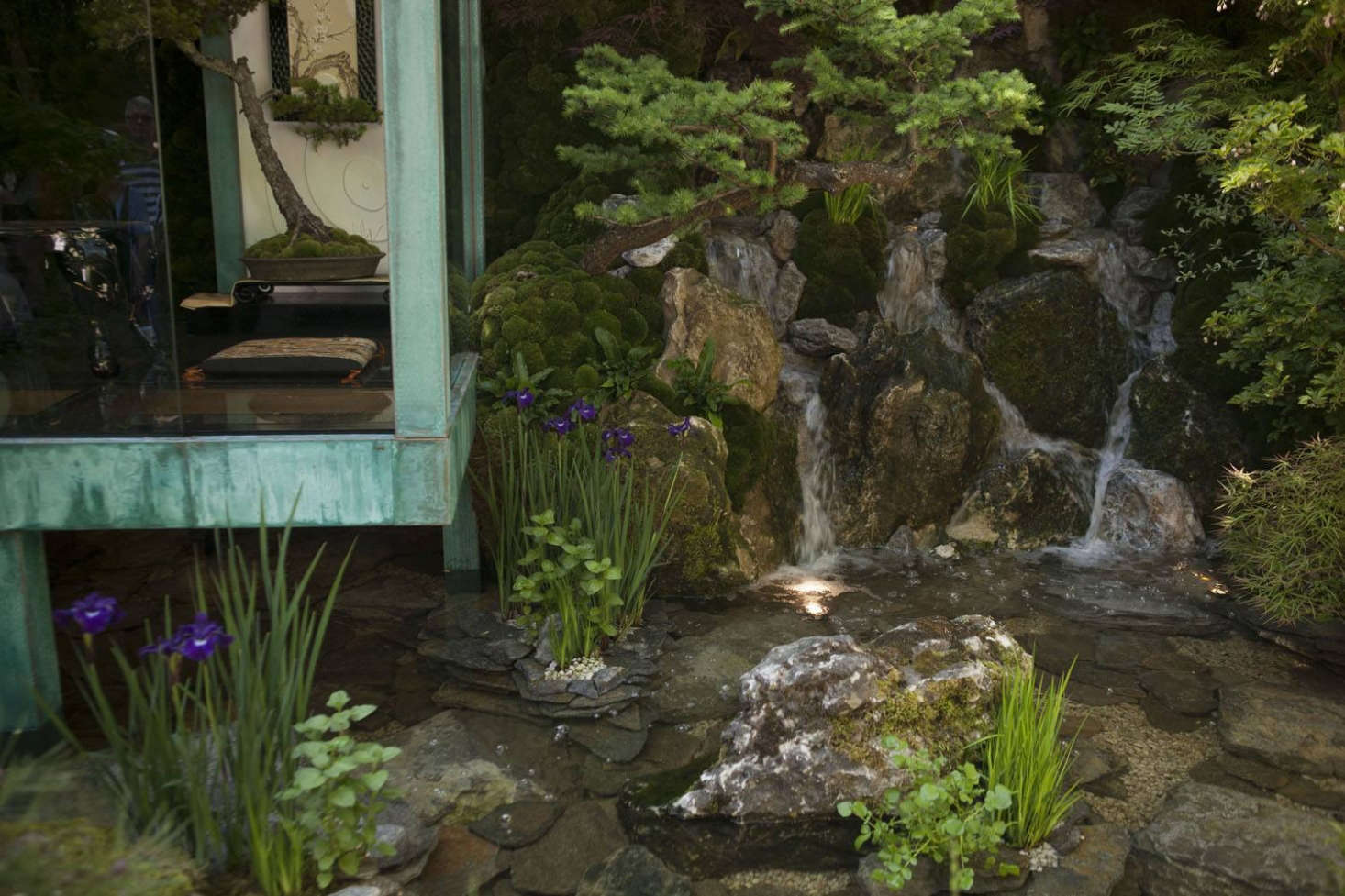 Perfectly assembled: the right angles of the structure give weight to the spikes of water plants by flat, wide stones. Even the water by the building is vertical as well as horizontal.