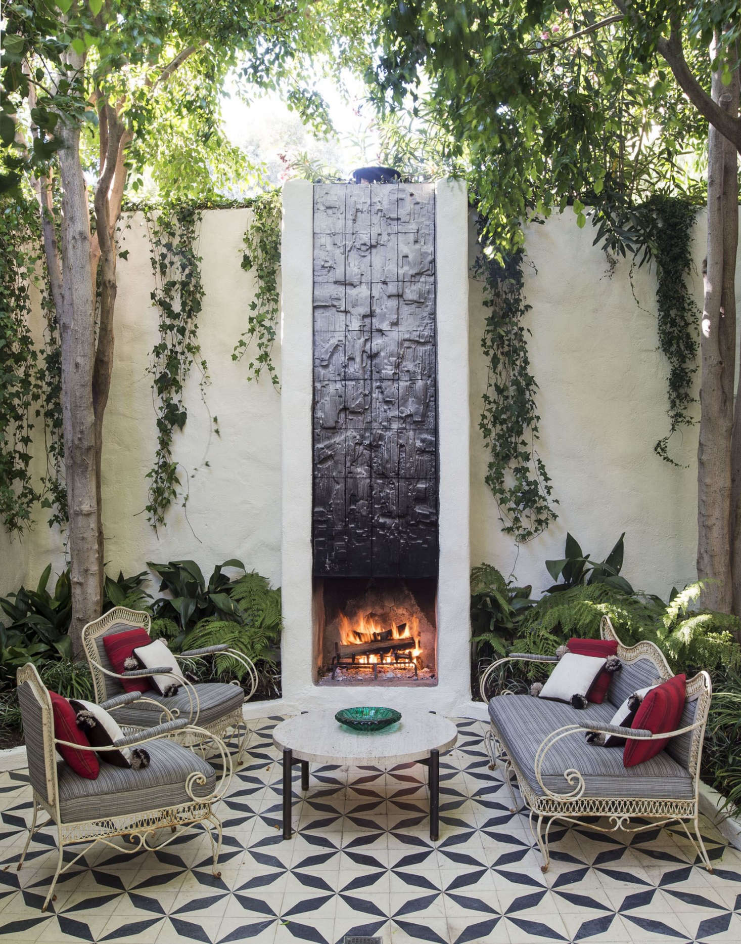A tall, narrow fireplace with a tiled mural by sculptor Stan Bitters develops a glossy ebony patina from smoke (and is easily washed off).