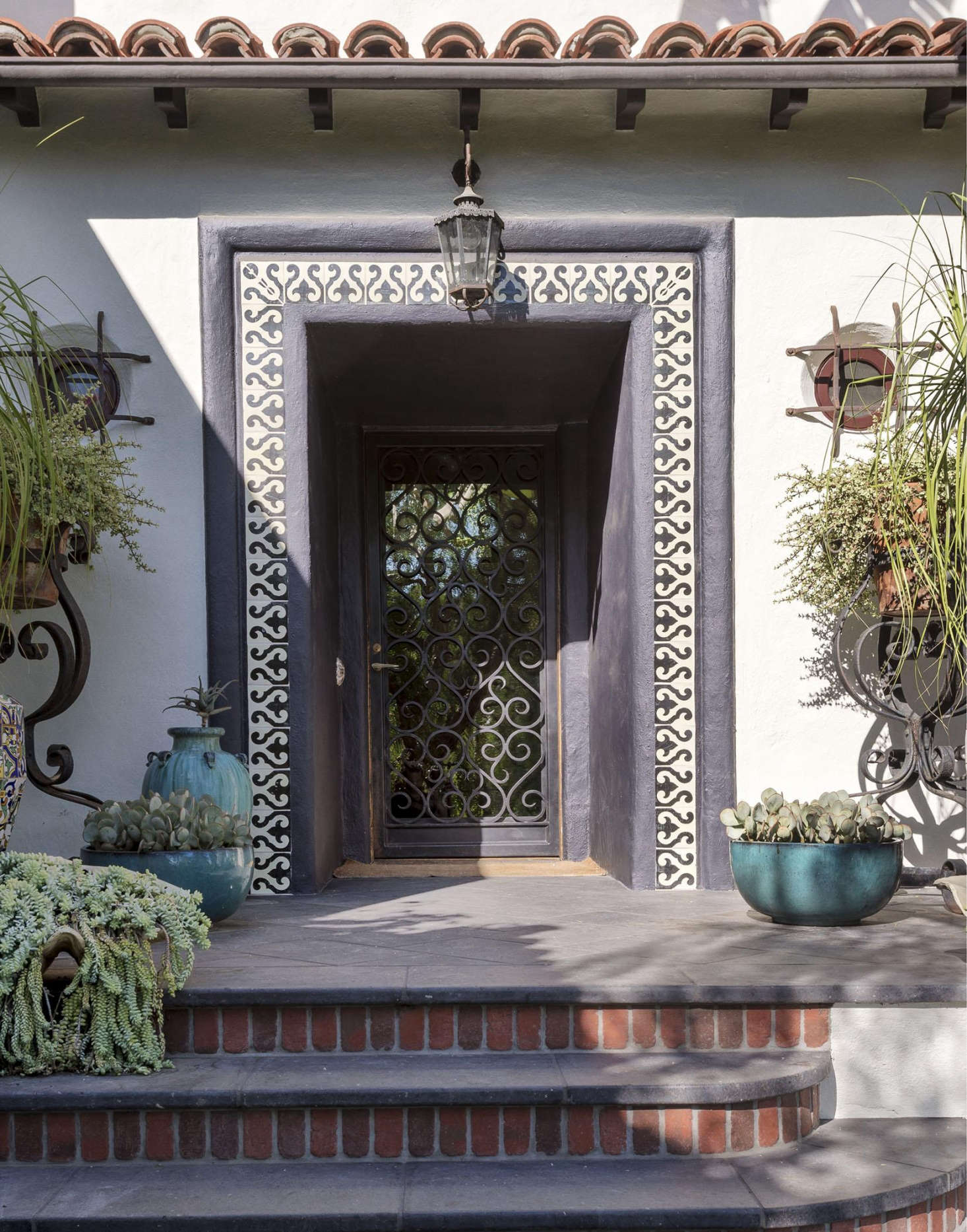 Designers (and siblings) Ramin and Pam Shamshiri added curb appeal to a 1920s Hollywood garden with reclaimed ceramic patterned tile on a stucco facade and redbrick detailing on an entry stairway.