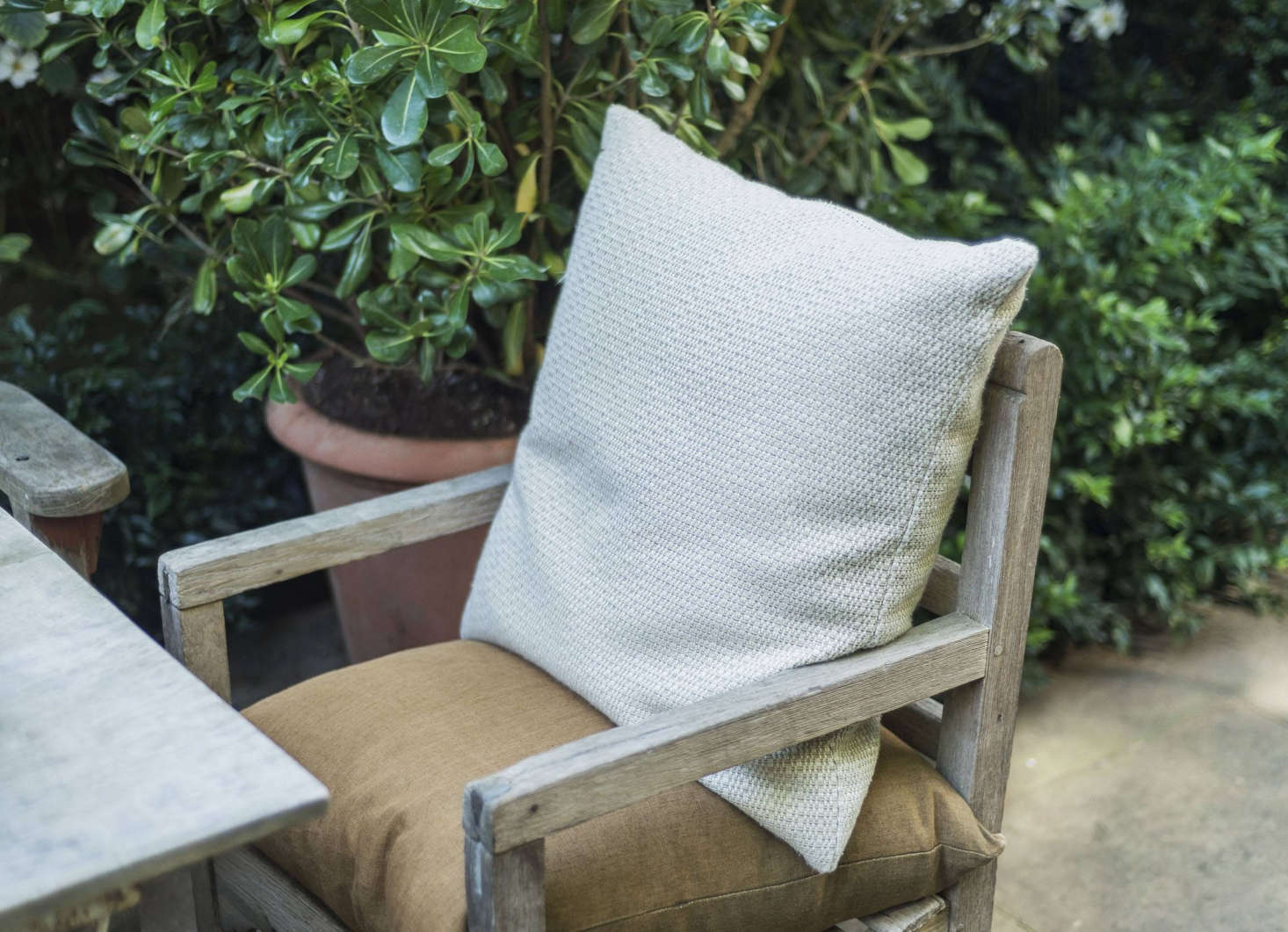 Weathered teak chairs and benches have cushions for extra comfort.