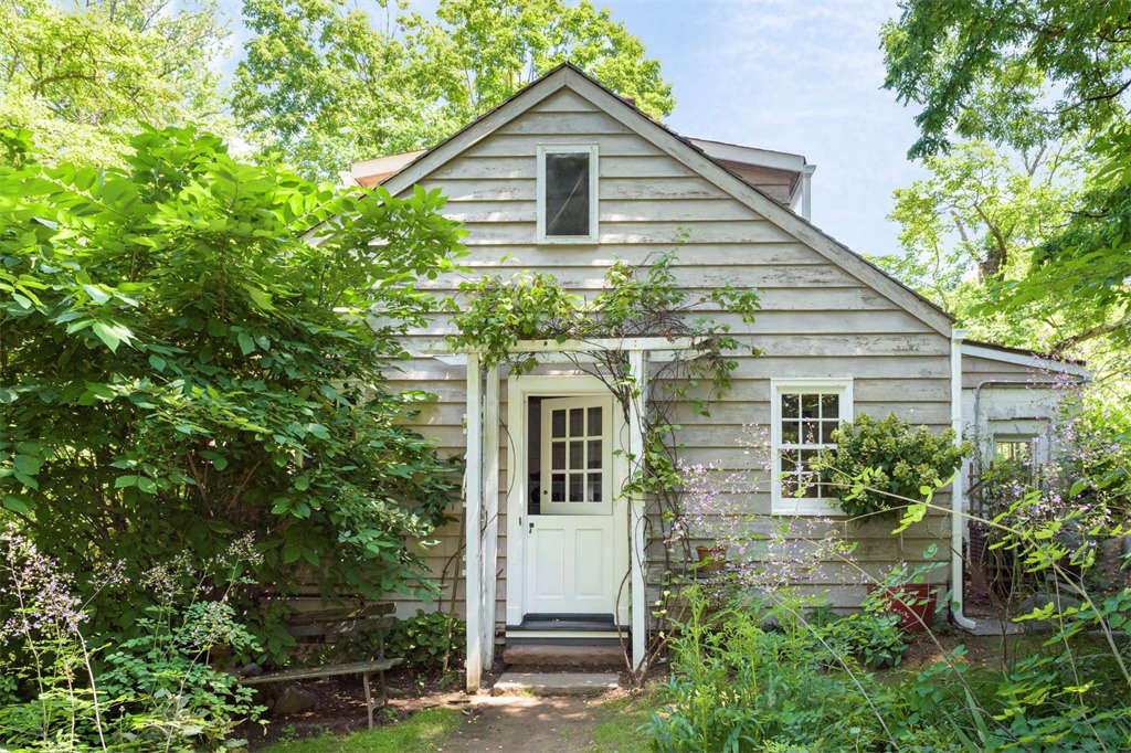 A welcoming Dutch door is framed by a trellis covered with climbing vines.
