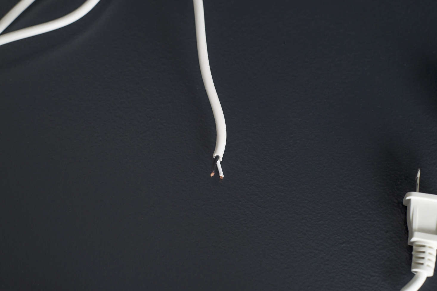 Use a wire stripper to strip off about a half inch of casing to expose the two wires on the cord’s open end. Follow the installation instructions included with your plug to attach the wires to the plu