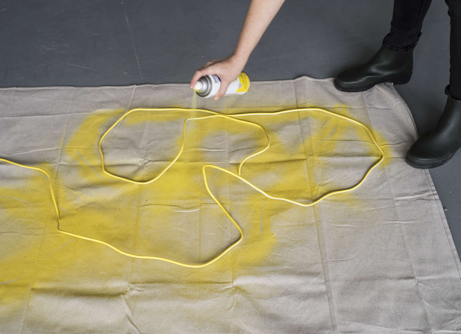 Cover a work surface in a well-ventilated room or outdoors with a drop cloth. Paint the cord with two coats of glossy yellow spray paint. Let dry between coats.