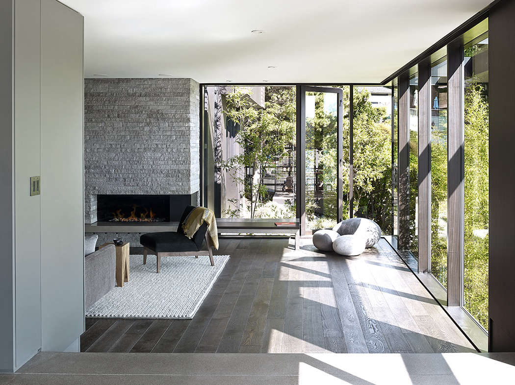 The living room, as seen from the dining room. The windows open onto a side garden of shrubs and perennials.