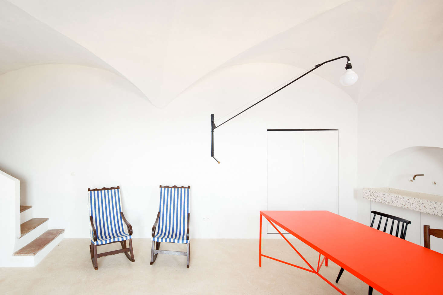 Inside, the effect is bright and beach-like. With two traditional Mallorcan rocking chairs—found in the house and reupholstered in blue and white striped fabric—and a traditional lime floor called trispol that feels cool under bare feet, the interiors have the air of summer about them.