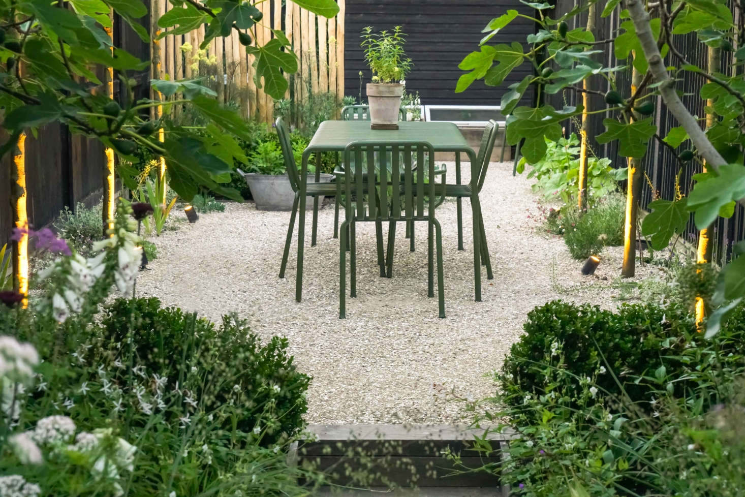 Two “characterful” fig trees frame the view of the simple dining terrace, which is reached via the sunken oak boardwalk through long borders either side,” Farlam says.