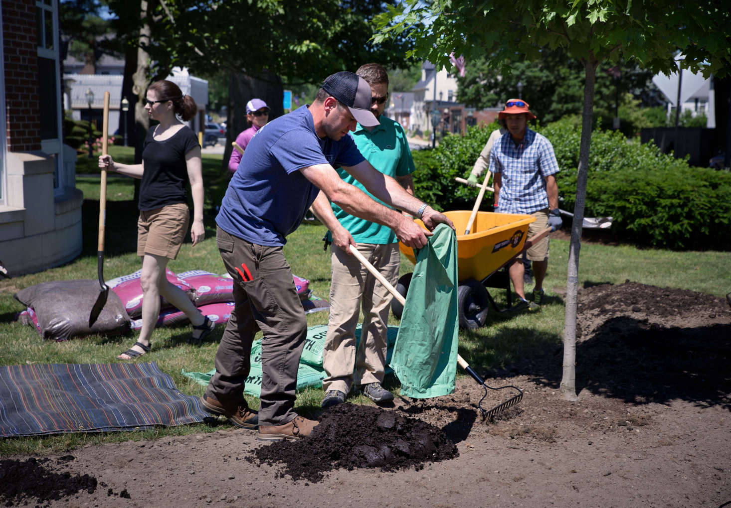 With the help of his class, Mark Richardson adds local, organic compost to the site. The New England Wild Flower Society uses only compost and organic mulch to enrich its soil, never fertilizers.