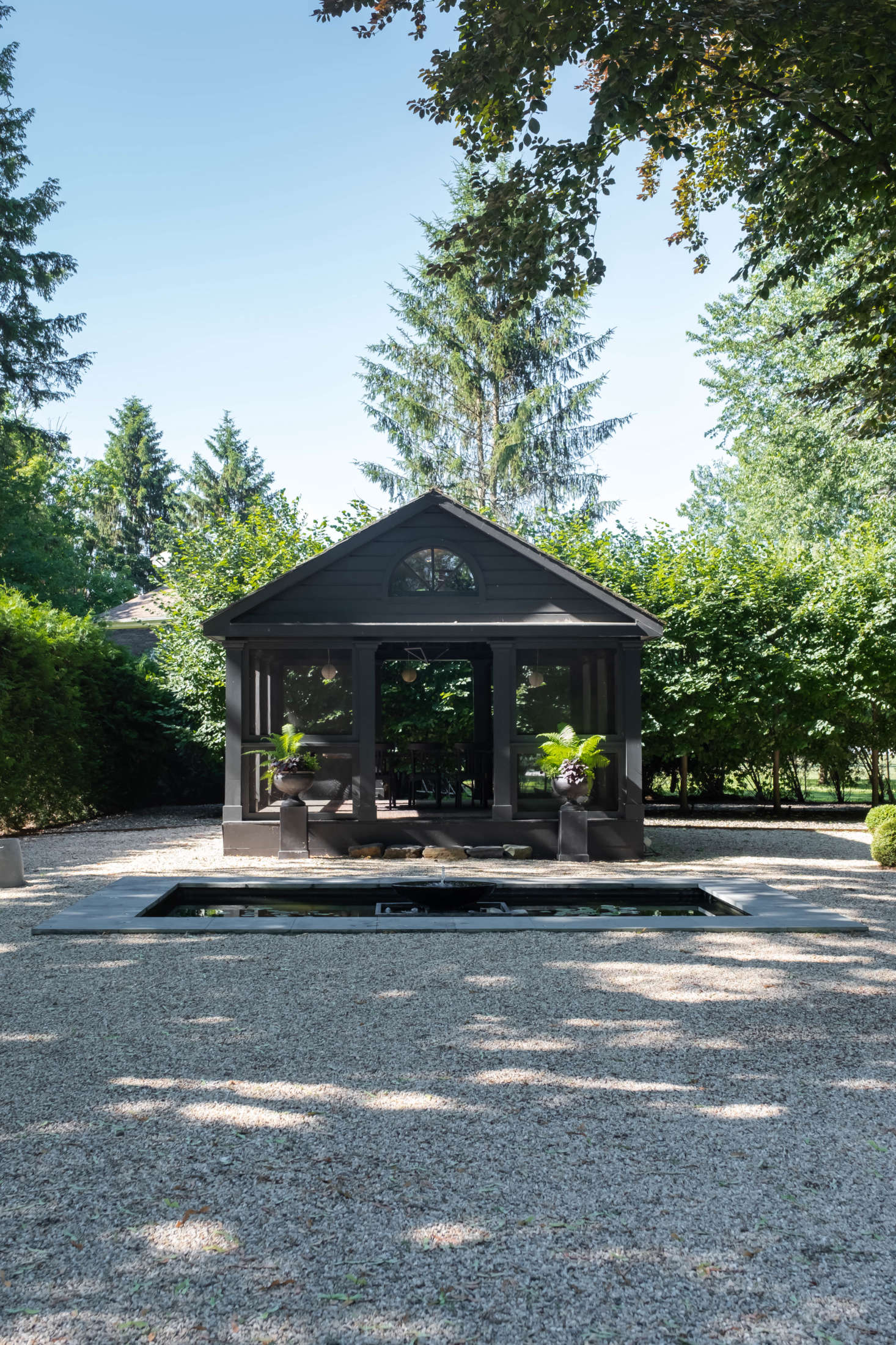 Beyond the hedges lies the garden’s piece de resistance: a long, formal gravel garden, centered by a screened outbuilding (for long, warm-weather dinners) and a shallow reflecting pool.