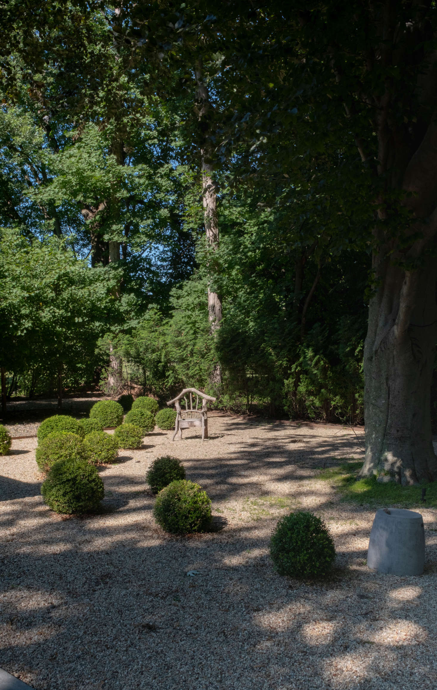 A moment of whimsy: spherical boxwoods dotted around the grounds, and a driftwood chair, left behind by the previous owner. “The boxwoods get hand-trimmed twice a year, in spring and early fall,” Dealtry says. “It’s a learning curve; I hope it gets faster!”