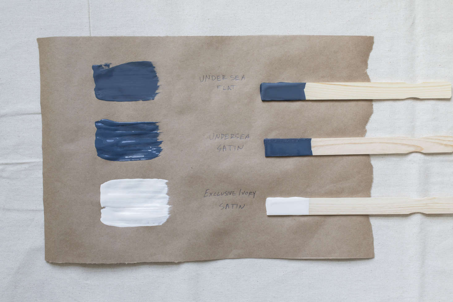 A stately navy palette includes Behr’s Undersea in flat finish for the main house color, the same tone in its satin finish for the trim, and Behr’s Exclusive Ivory in satin for a fresh front door.