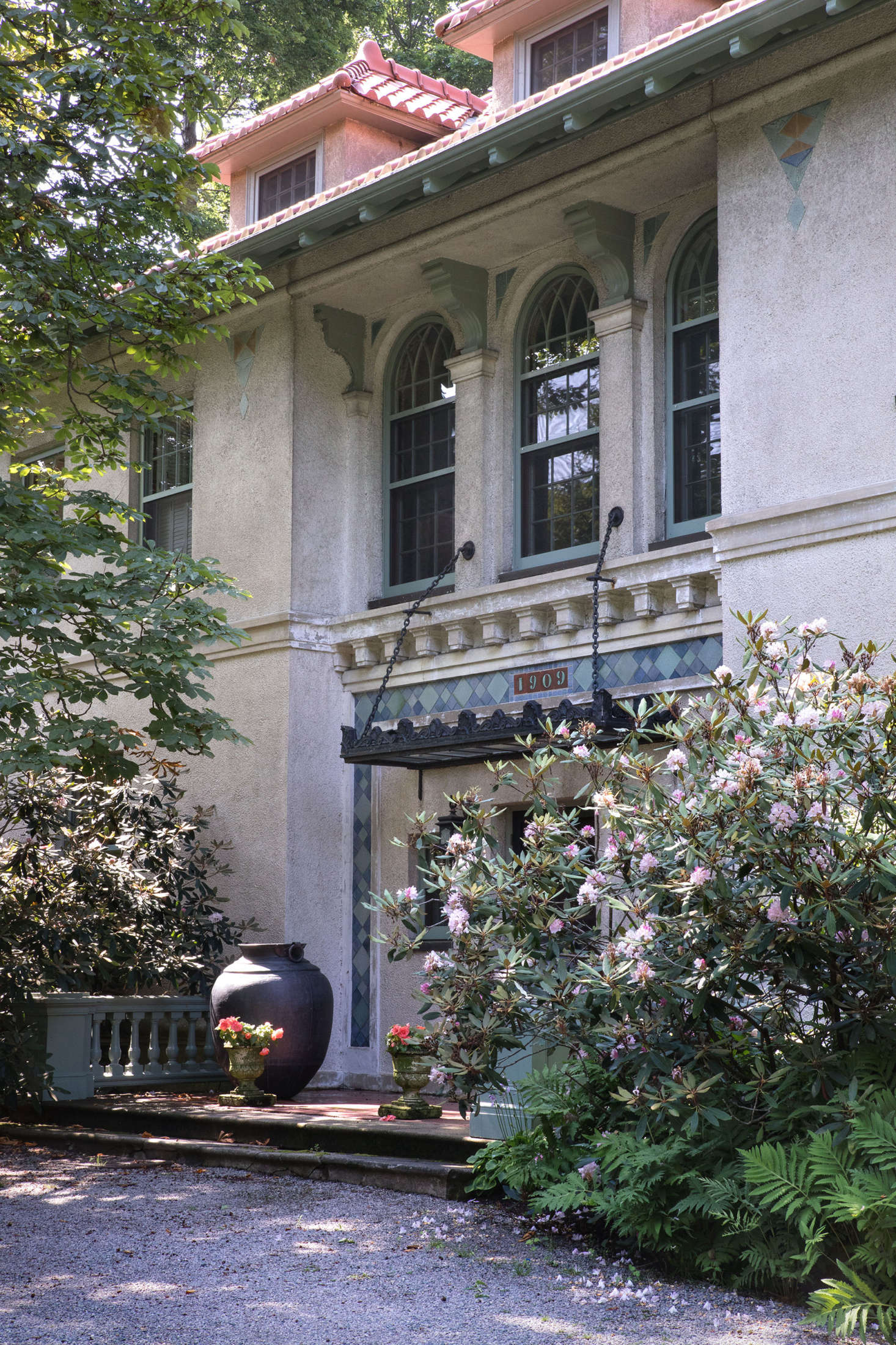 Flanked by ferns and mature rhododendrons, the front entrance of the house maintains a stately appearance.