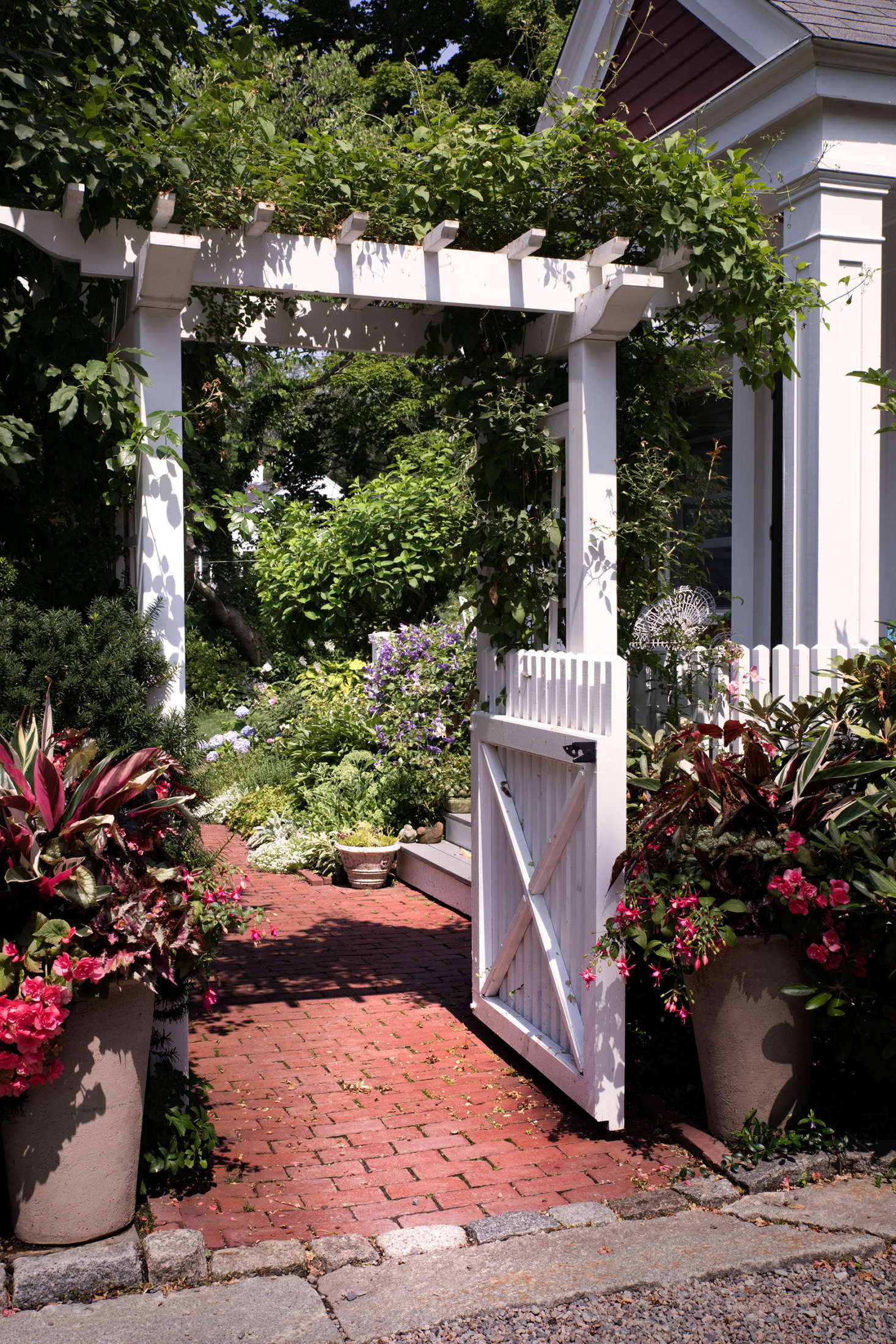 Located at the back of the property, the main garden and outdoor recreation areas are hidden from the road and driveway by the homes as well as flowers, trees, pergolas, and a quaint picket fence. Through one of only several entrances to this secret garden, a historically inspired brick path leads through the garden gate.