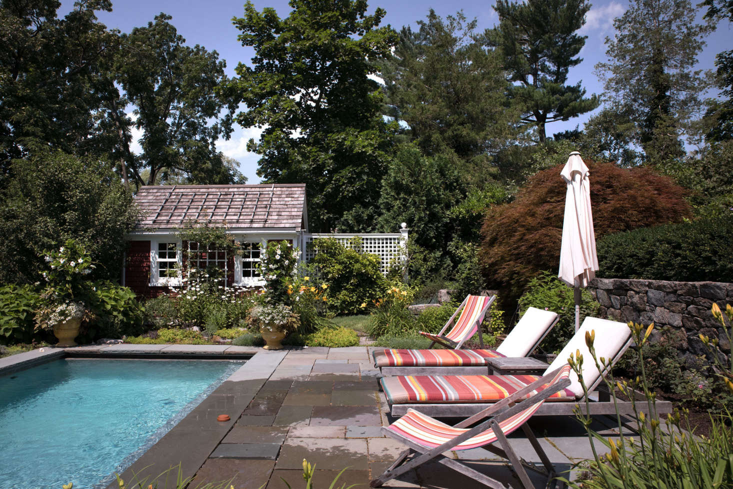 A patio made from natural-cleft bluestone provides a secluded lounging spot.