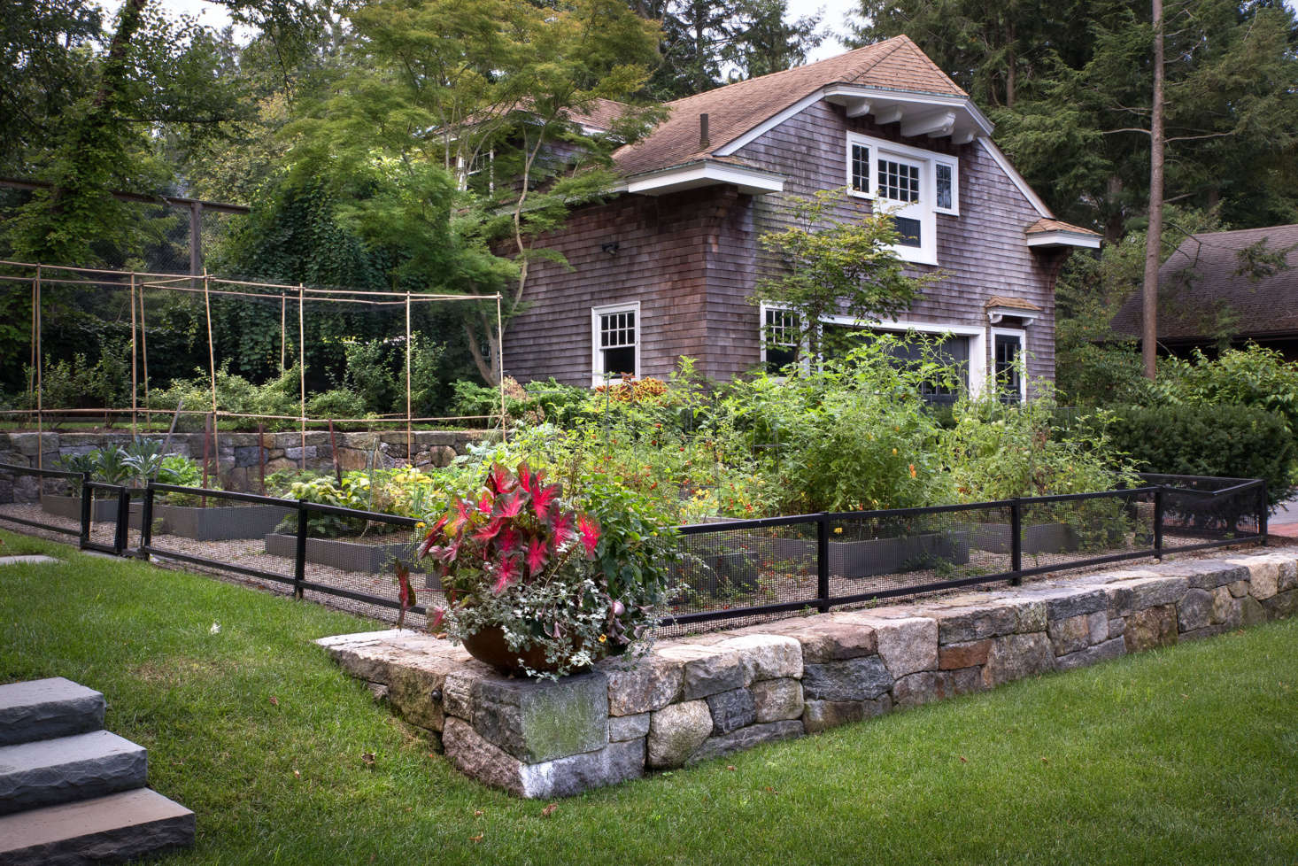 Disappearing into the level above, the stone walls both define and seamlessly blend the distinct parts of the yard.